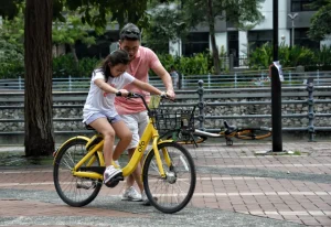 A father teaching his daughter to ride a bike