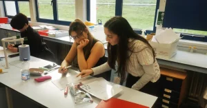 GTL instructor helping students with their work during the 2023 Global Teaching Labs in Wales programme