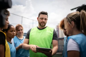 A coach explains tactics to his football team