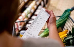 woman checks receipt after buying groceries in a supermarket